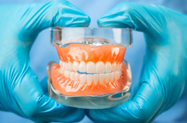 Dentist fitting dentures for a patient